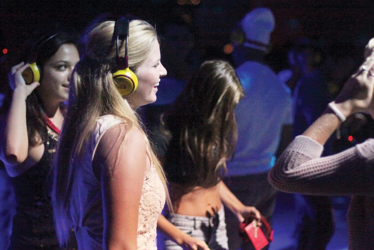 People having fun at the Silent Disco party in London at the Natural History Museum People enjoying the Silent Disco party in London at the Natural History Museum, dancing with wireless headphones