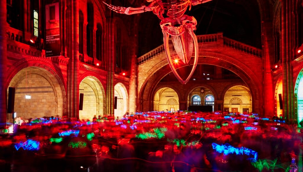 Silent Disco at the Natural History Museum with guests dancing under Hope the blue whale skeleton.