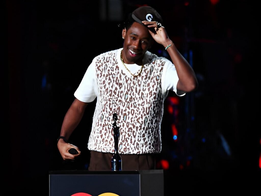 Tyler The Creator UK Tour 2925 Tyler, the Creator performing live on stage with bright lights and a cheering crowd during his 2025 UK tour