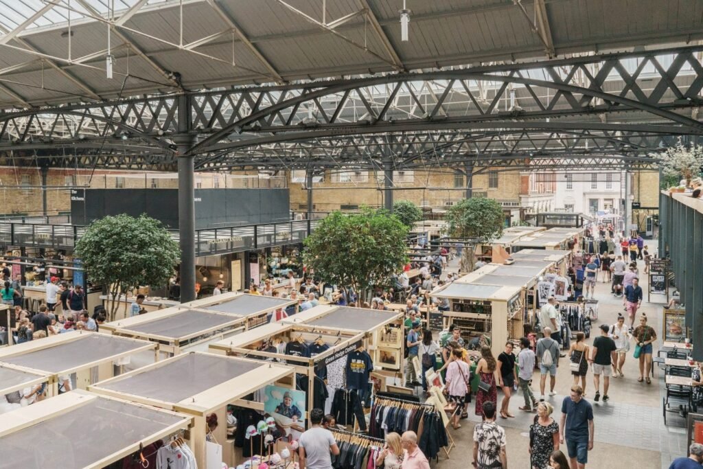 A vibrant scene at Old Spitalfields Market, with stalls selling unique fashion and antiques