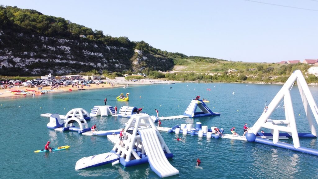 St Andrew Lake – Best day trip from London for water activities A peaceful view of St Andrew Lake in Kent, with crystal-clear water, lush greenery, and people enjoying water sports like wakeboarding and paddleboarding